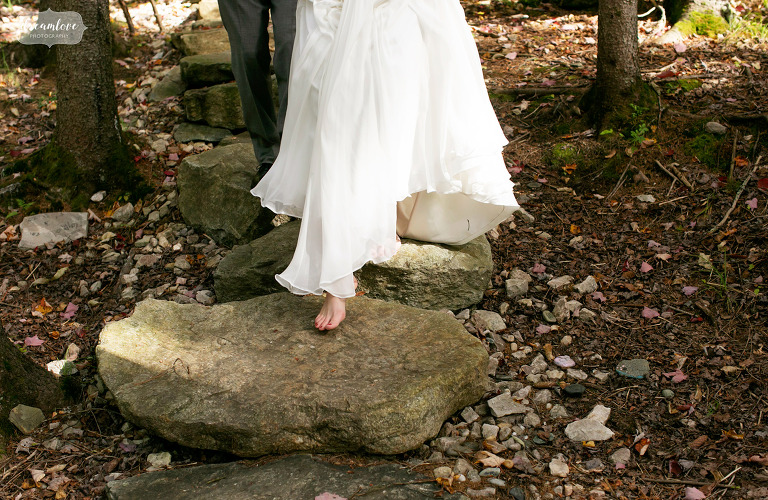 A bride's bare foot walks over rocks at her Berkshires wedding.