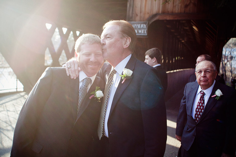 Father of the groom gives his son a kiss before a wedding in Woodstock, VT. 
