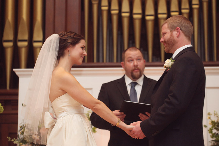 Bride and groom smile at each other during their wedding ceremony in Woodstock. 