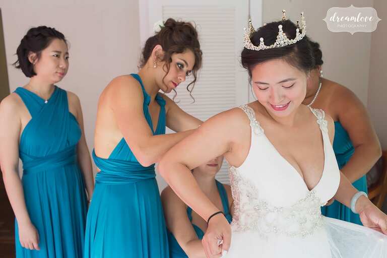Bridesmaids help put the dress on in teal etsy dresses.