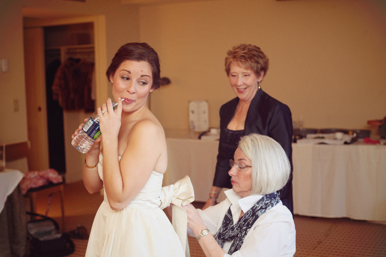 Mother of the bride helps her tie on a bow before getting married at the Woodstock Inn. 