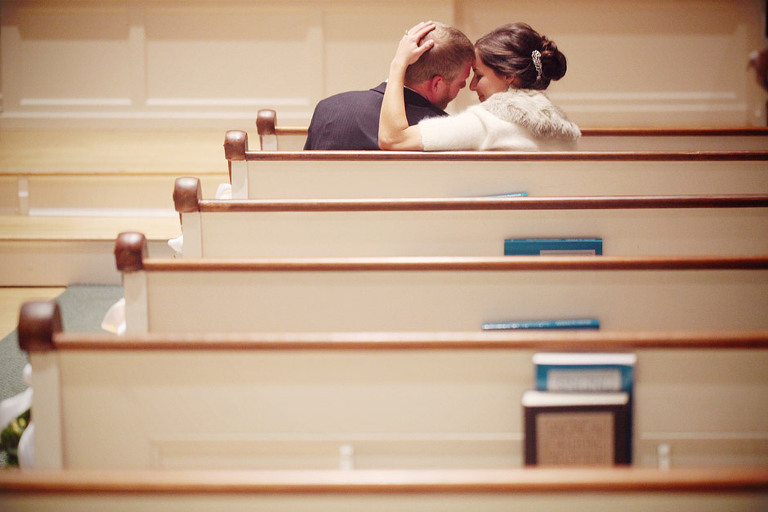 Bride and groom share a sweet moment in the pews at the North Universalist Chapel. 