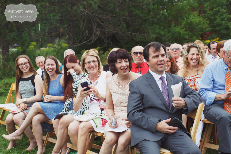Wedding guests smiling during ceremony procession at Topnotch Resort in Stowe, VT.