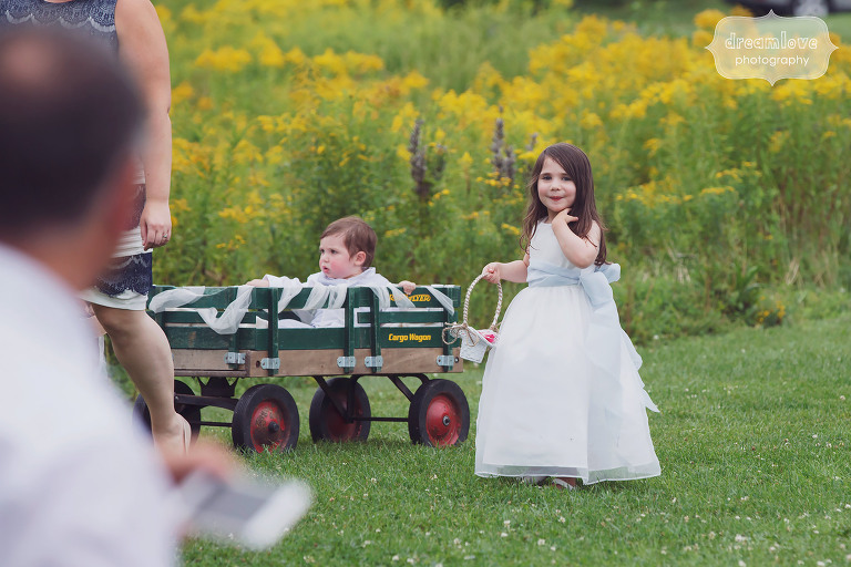 Adorable flower girl with ring bearer in wagon at Topnotch Resort in Stowe, VT.