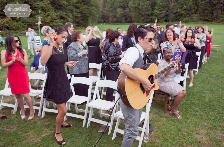 Wedding guests play music from their seats during an outdoor ceremony in Vermont. 