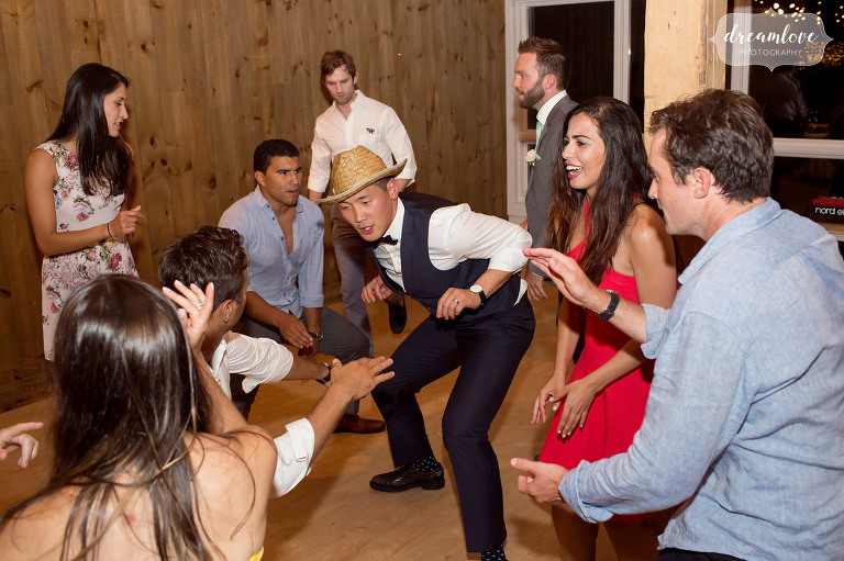 Funny photo of the groom dancing with a straw hat at the Inn on Main in Wolfeboro, NH.