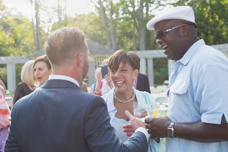 Happy wedding photography of the guests mingling in Manchester by the Sea backyard wedding.