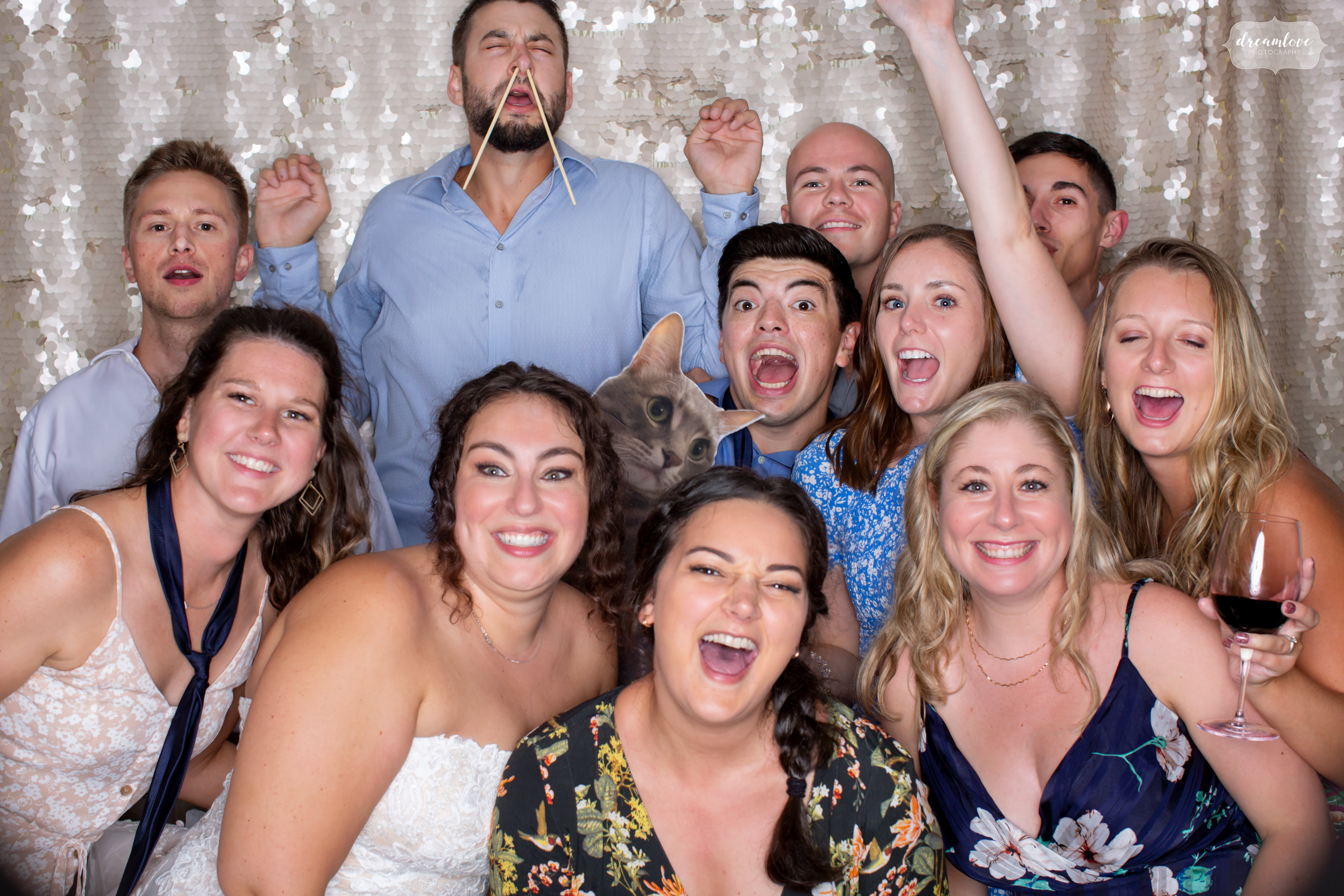 Wedding guests having fun in a photo booth at Moraine Farm in MA.