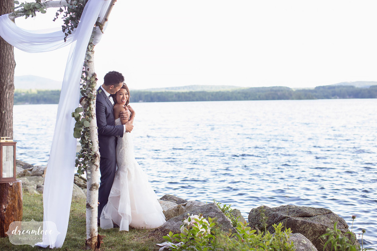 Bride and groom stand on the shore of Lake Wentworth after their Wolfeboro NH wedding.