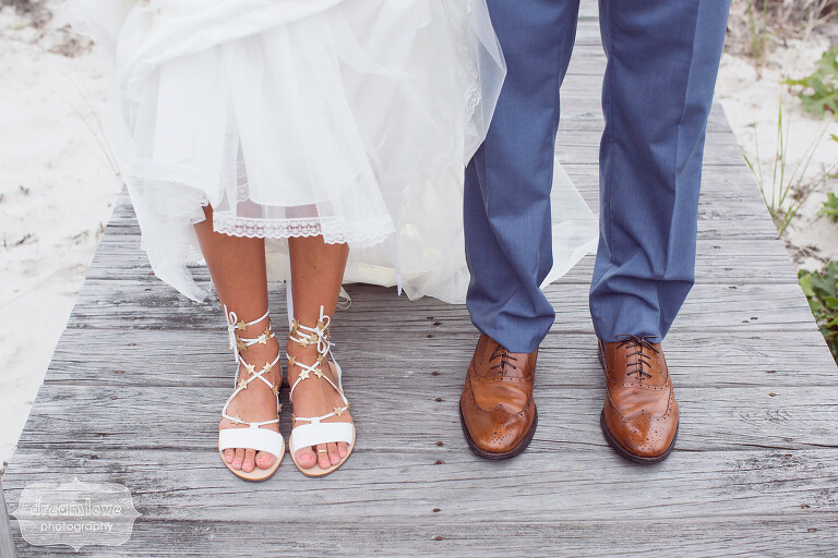 Quirky wedding photo of the bride and groom's feet on an old wooden boardwalk on Cape Cod.