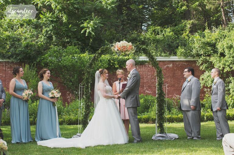 English garden outdoor wedding ceremony with a floral arbor with ivy at the Lyman Estate.