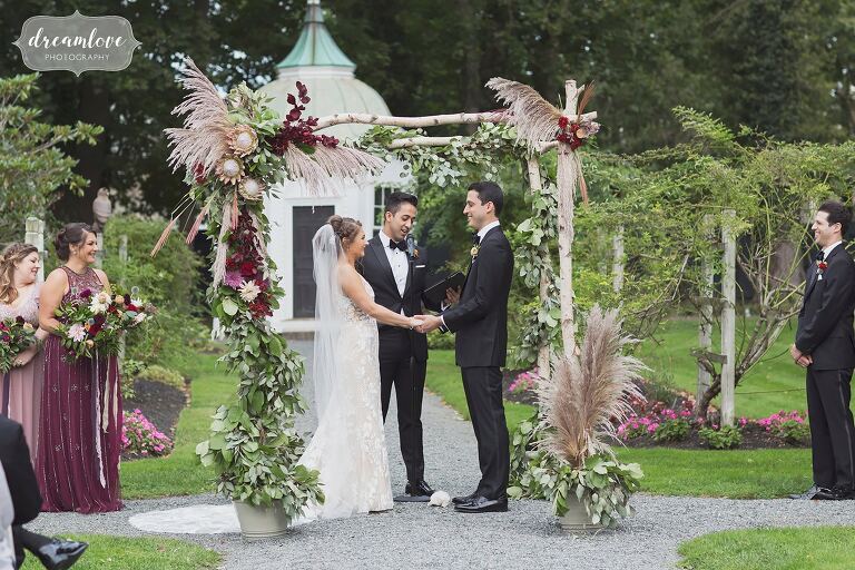 The chuppah is decorated with floral garlands for September RI wedding.
