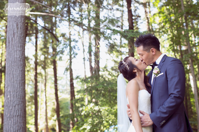 Romantic wedding photography of the bride and groom kissing in the forest in NH.