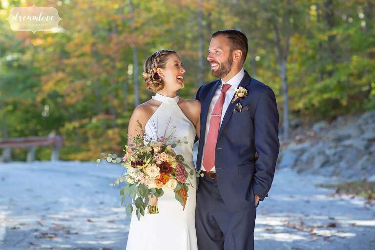 Bride and groom surrounded by fall foliage.
