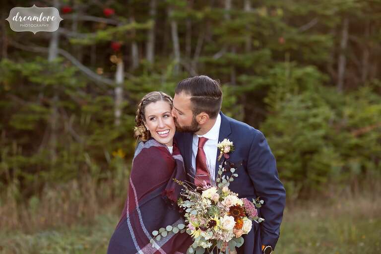 Bride wrapped in a plaid blanket on top of Stratton Mountain.