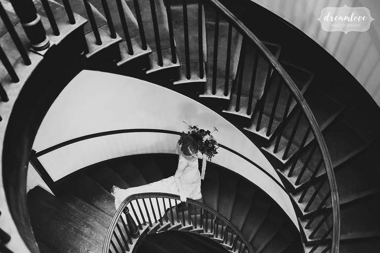 Artsy wedding photo of bride walking down spiral staircase at the Linden Place.