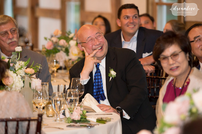 The father of the groom smiles while listening to toasts at the Inn on Main in Wolfeboro.