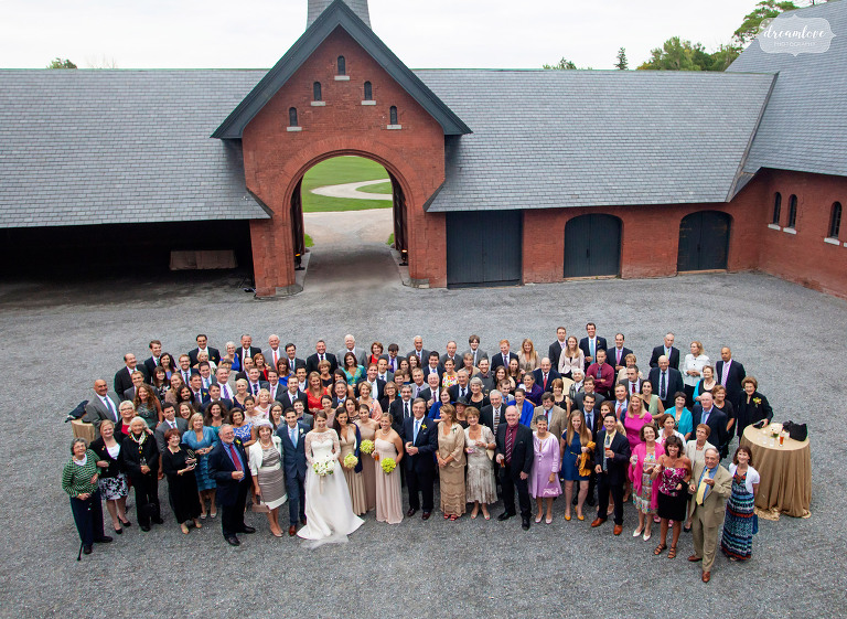 Grande photo de groupe d'invités de mariage à Coach Barn à Shelburne Farms.
