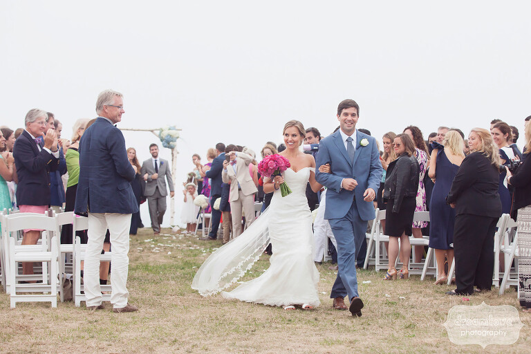 Happy bride and groom exit their ceremony at this lighthouse wedding on Cape Cod.