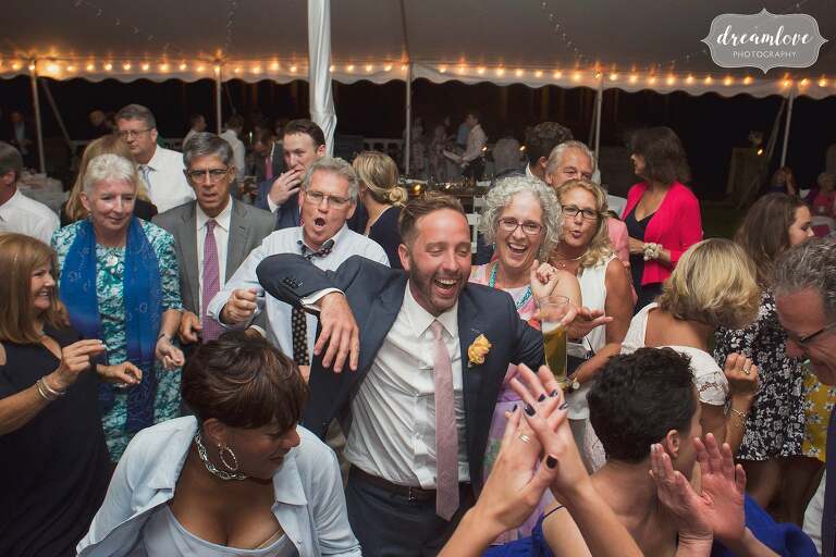 The groom laughing in the center of the dance floor in Manchester by the Sea.