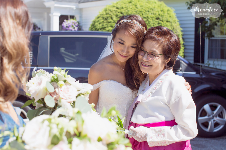 The bride hugs her mother, who is wearing a traditional Korean outfit for the wedding in NH.