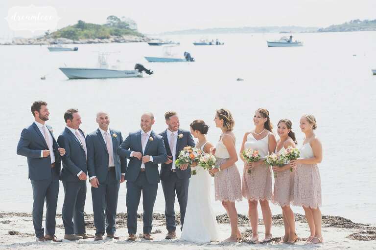The wedding party poses on Singing Beach in BHLDN skirts and white tops on the north shore of MA.