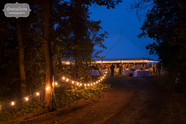 Romantic reception tent walk with cafe lights to Cape Cod wedding.