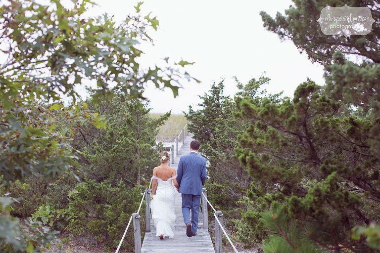 Wedding portrait of bride and groom on boardwalk to beach on Cape Cod.
