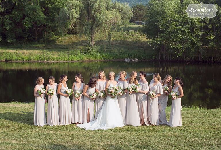 Lots of bridesmaids in front of pond at One Barn Farm.