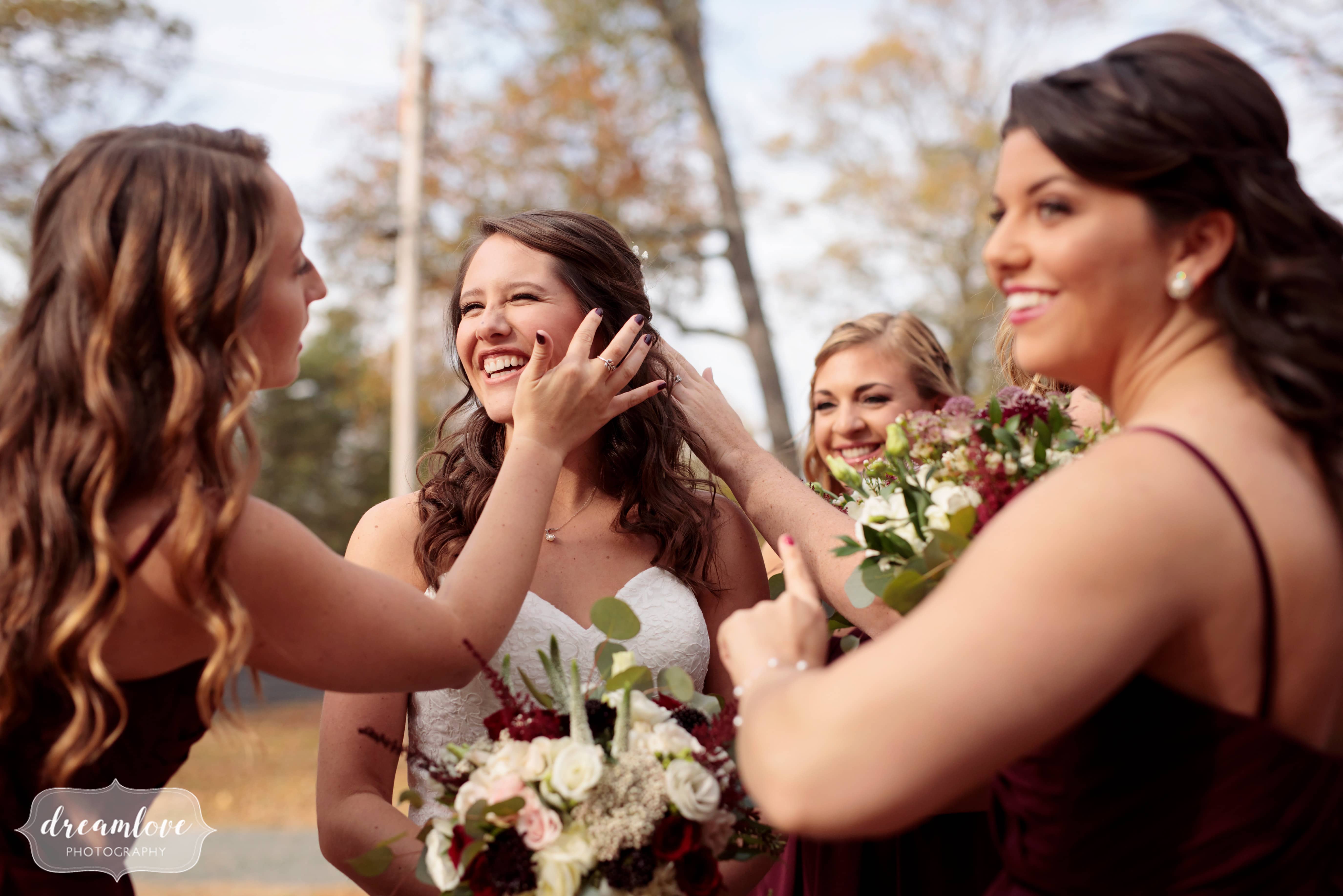 Happy wedding photography of the bride being helped by her bridesmaids at Pavilion on Crystal Lake wedding.