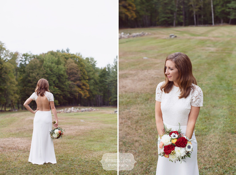 The bride poses in a simple backless wedding dress in the field at the Curtis Hollow Farm in VT.