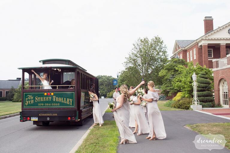 Bride waves from the trolley after her wedding on Bucknell campus.