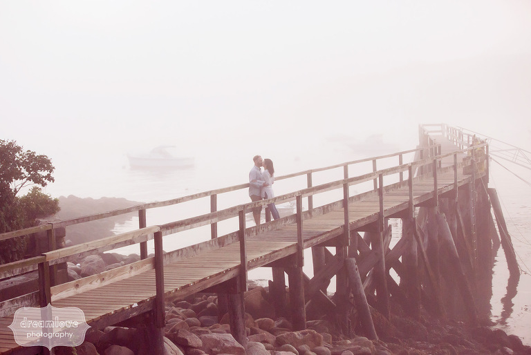 Coastal engagement photo of couple on the pier with ocean landscape in Manchester-by-the-Sea.