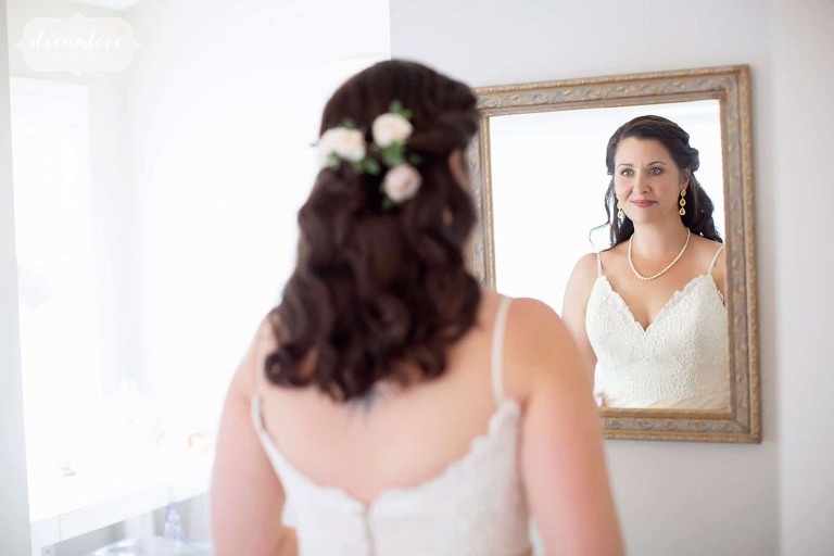 Bride looks in mirror at western Mass wedding.