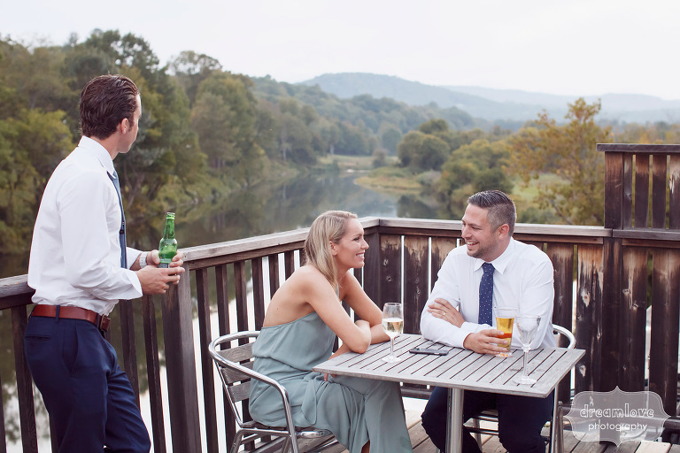 Wedding guests enjoy an outdoor cocktail hour overlooking the Ottauquechee River in southern VT.