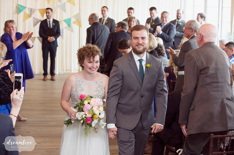 Bride and groom exit their indoor ceremony at the Wychmere Beach Club.