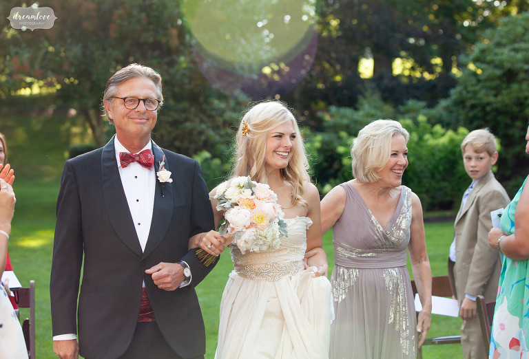 Bride walks down aisle between her mom and dad at Glen Manor House.
