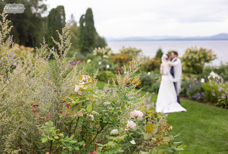 Bride and groom kiss in a garden at Shelburne Farms Vermont venue.