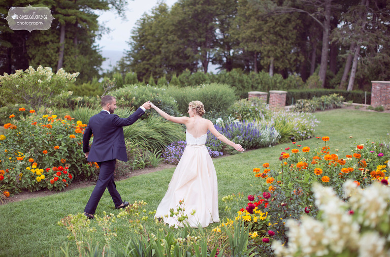 bride and groom dance among the wildflower gardens at the shelburne farms venue in vt