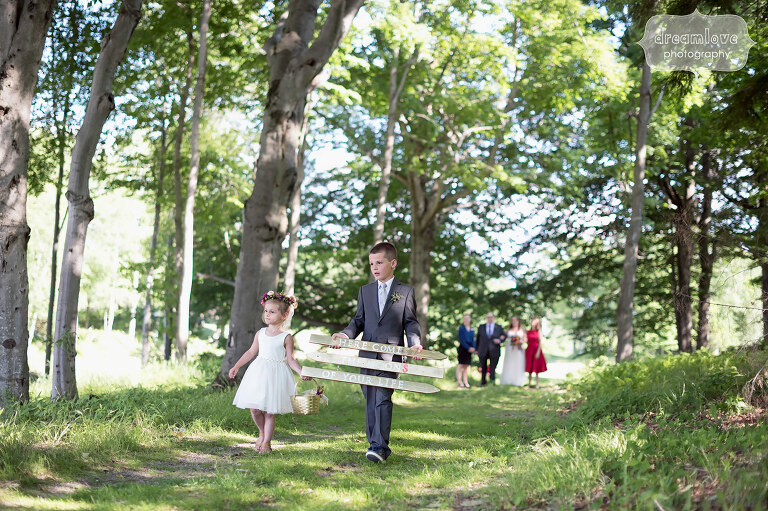 The flower girl and ring bearer walk through the woods before this June wedding in Sugarbush, VT.