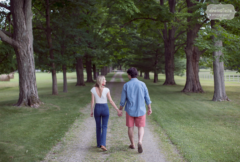 Engagement photo of couple holding hands and walking down a gravel path in FDR Park in Hudson Valley, NY.