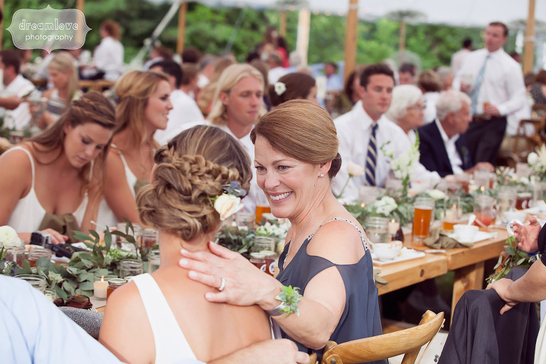 Sweet candid photo of the mother of the bride with her daughter during speeches at the wedding reception at the 1824 House in VT.