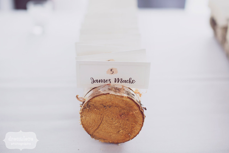 Great idea for a rustic wedding escort card display table–cut slots in a birch log and place seating cards in there.
