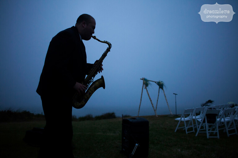 Artistic wedding photo at twilight of saxophone player.