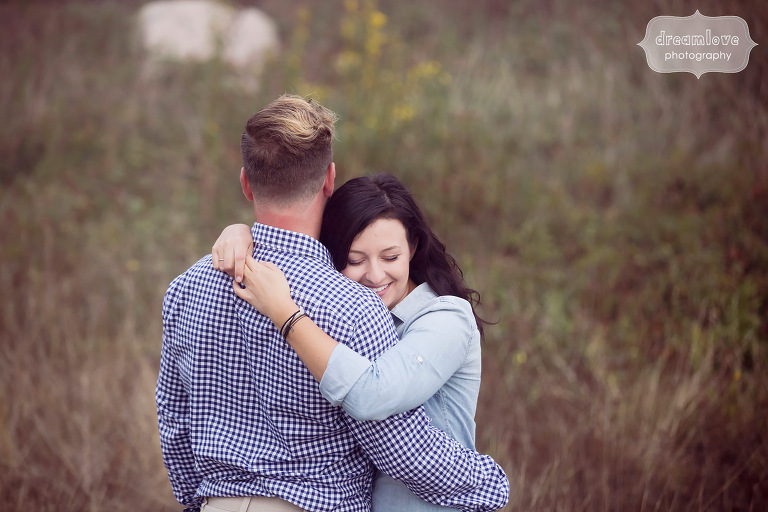 Happy photo of couple hugging during engagement photo shoot at the Coolidge Reservation.