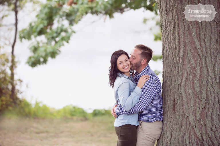 Couple kissing next to a tree during their Coolidge Reservation engagement session.