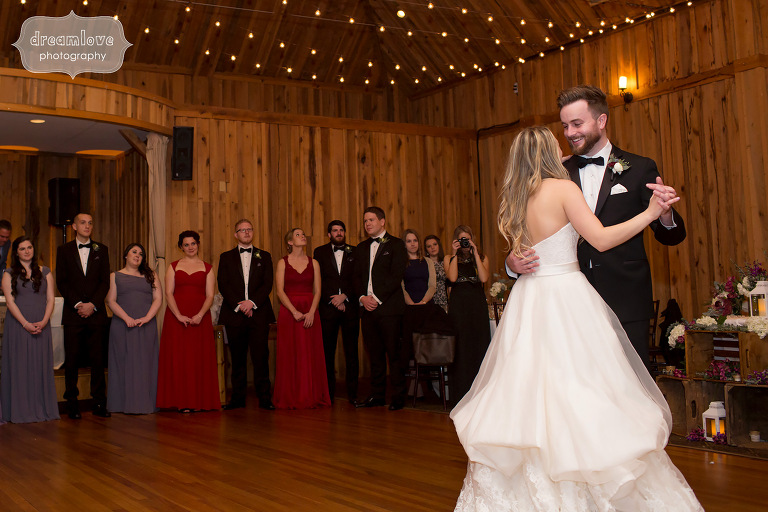 Bride and groom dance under a canopy of string lights at this CT camp wedding venue.