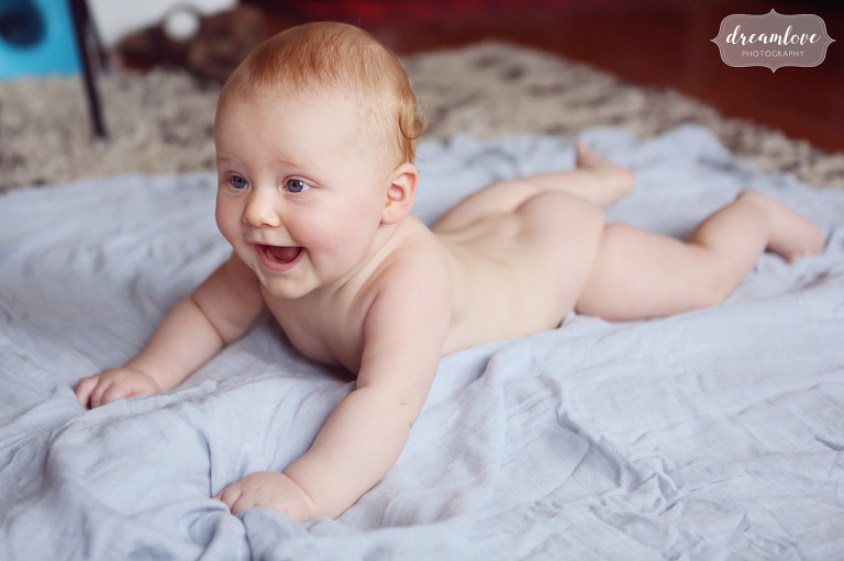 A six month old naked baby does tummy time on the floor at home in Venice, CA.