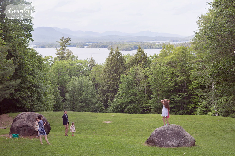 Kids playing in a field overlooking Squam Lake after a summer camp wedding on Squam Lake.