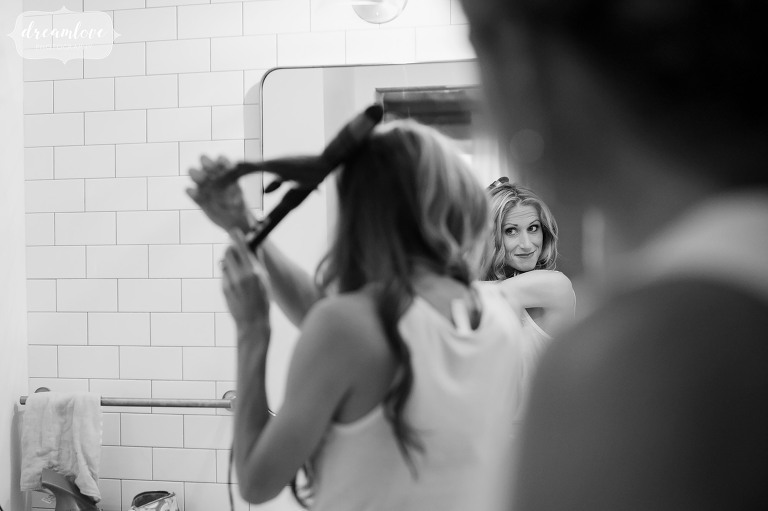 The bride looks in the mirror while getting ready for the wedding from her Farm Home in Stowe, VT.